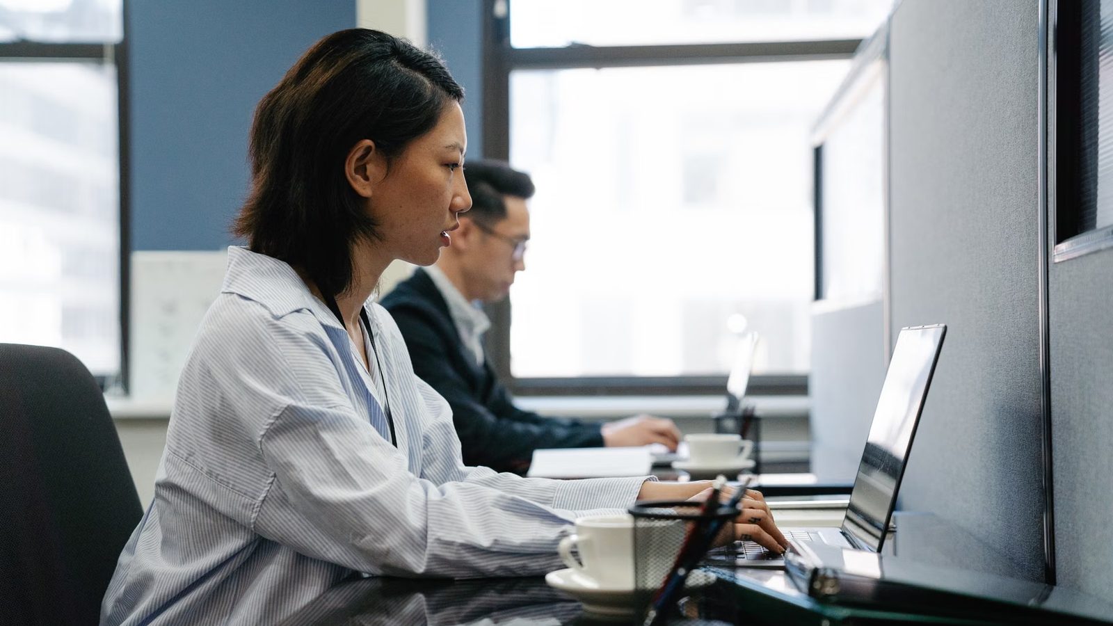 Two people working at computers in an office