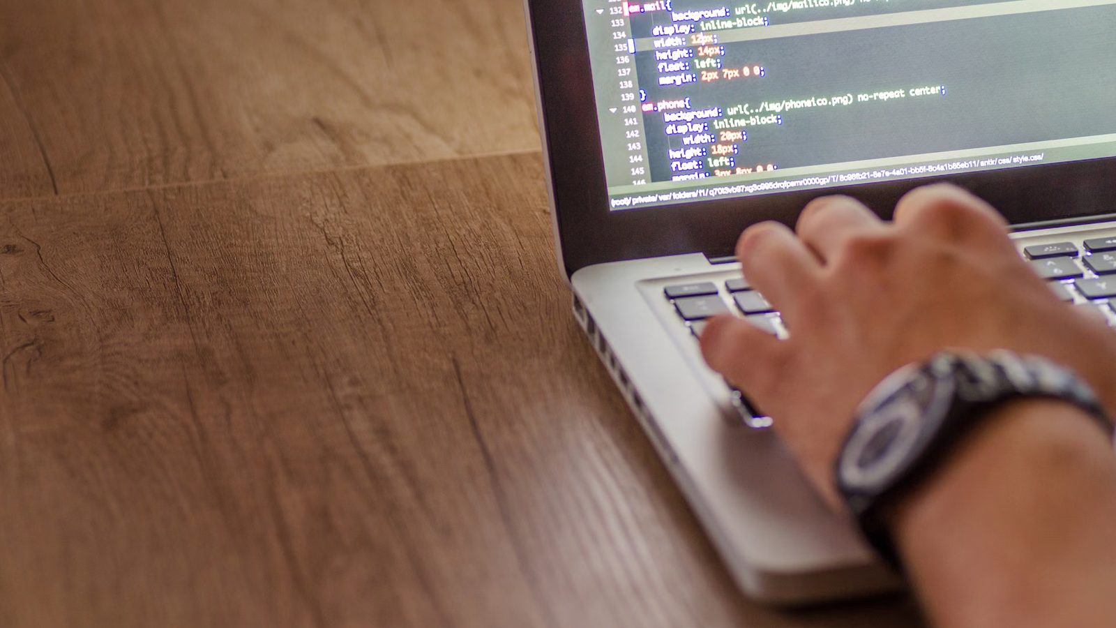 Developer writing code on a laptop