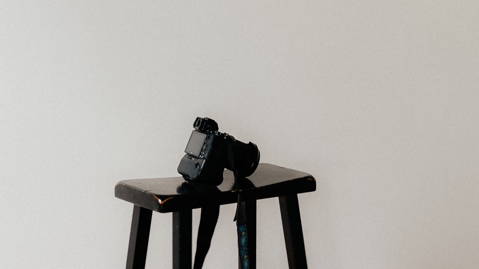 Camera on a tripod set up by a bright wall