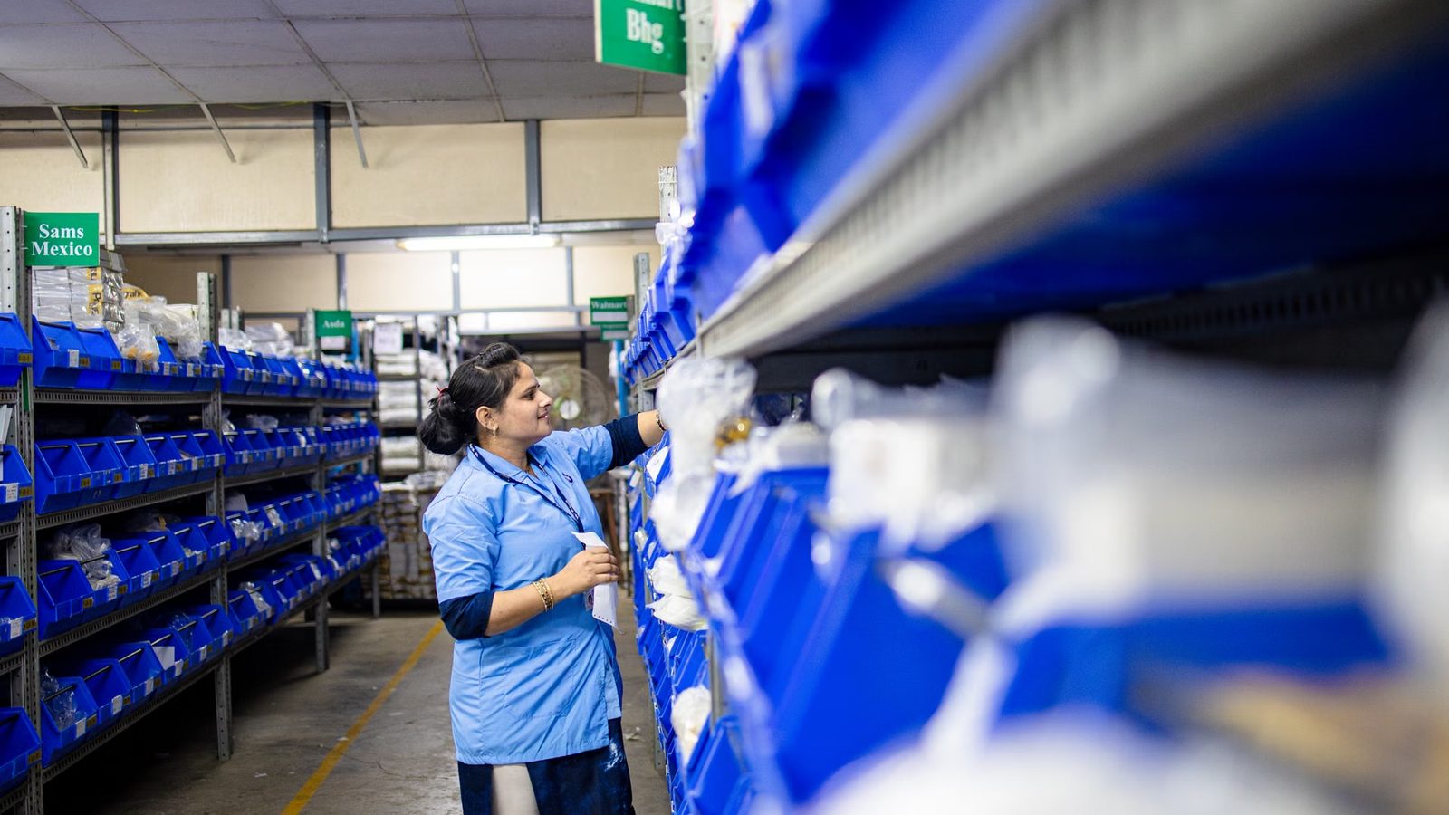 Employee picking an order between warehouse shelves