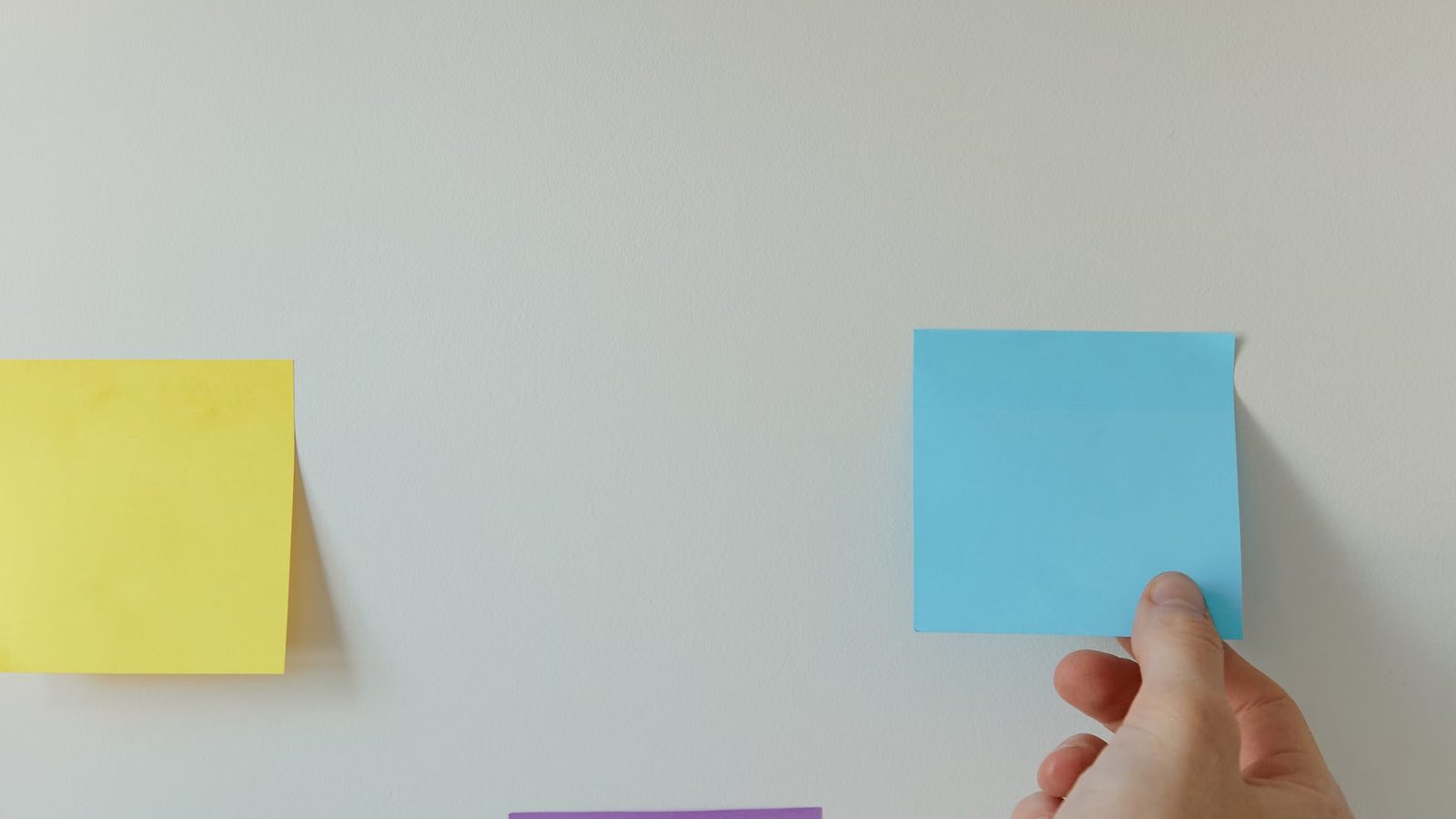 Sticky notes with project stages on a wall